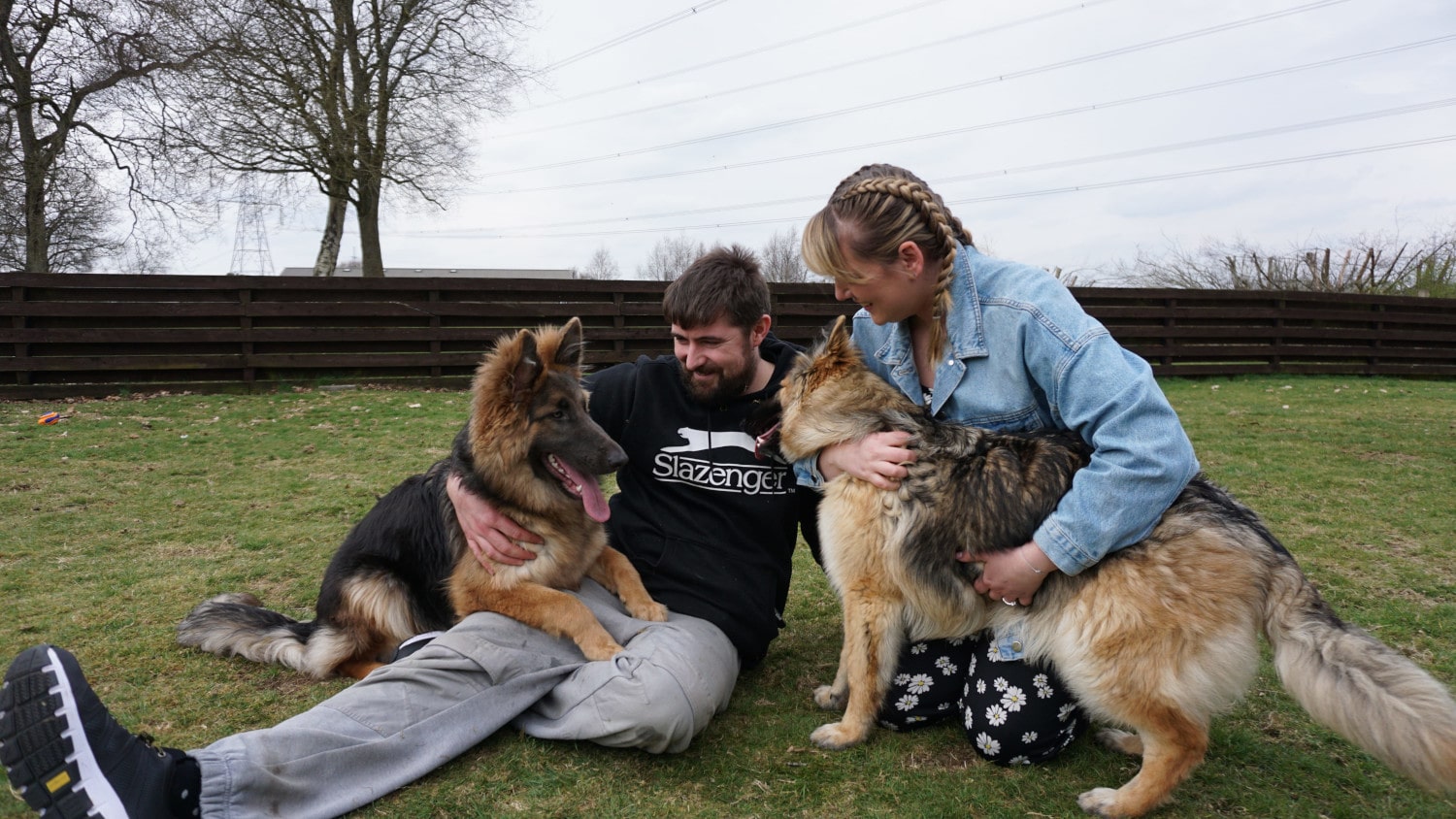 Picture of the owners playing with two of their puppies.